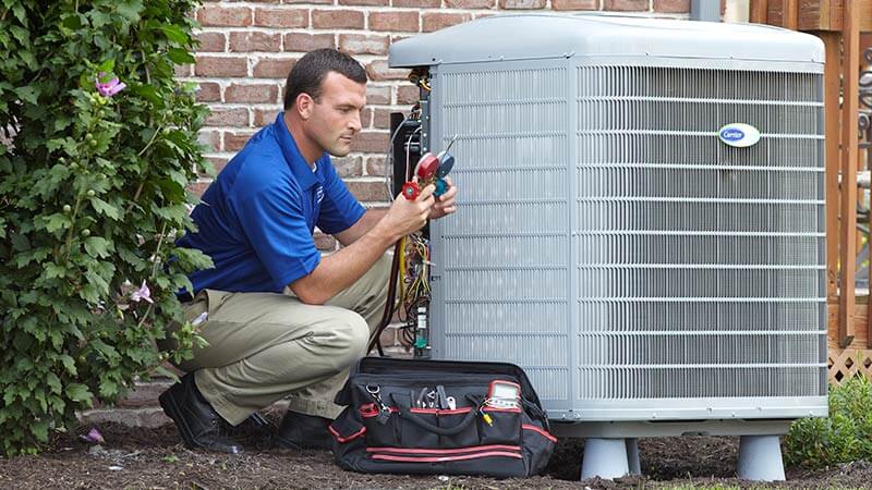 Service technician inspecting outdoor air conditioner unit