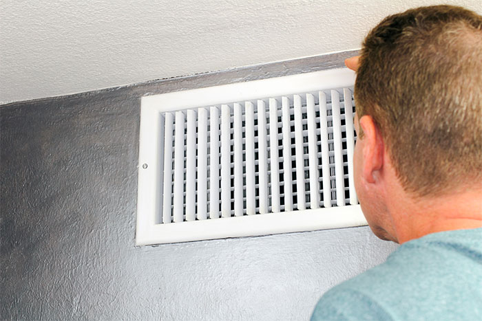 homeowner checking air vent